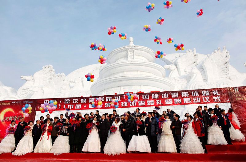 Пары принимают участие в групповой свадебной церемонии перед 
изображением Пекинского Храма Небес из снега 6 января 2010 года. Свадьба
 была организована правительством, и в церемонии приняли участие 28 пар,
 на которой присутствовали представители местных органов самоуправления.
 (REUTERS/Aly Song)