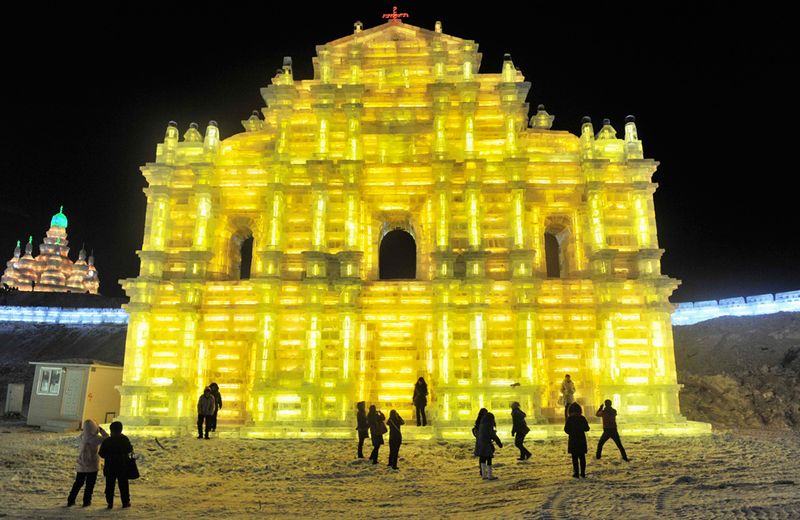 Люди пришли посмотреть на ярко освещенную изнутри ледяную 
скульптуру в Харбине 24 декабря 2009 года. (REUTERS/Sheng Li)
