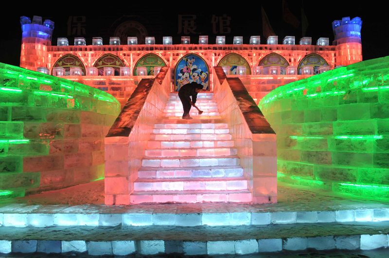 Рабочий чистит ледяную скульптуру в стиле Диснея перед открытием 
фестиваля снега и льда в Харбине 18 декабря 2009 года. (REUTERS/Sheng 
Li)