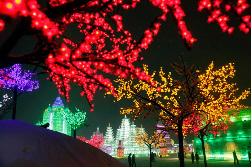 Освещенные яркими разноцветными гирляндами деревья и скульптуры в 
парке Харбина 6 января 2010 года. (AP Photo/Ng Han Guan)