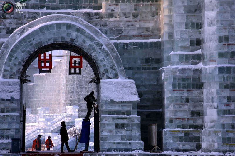 Рабочие завершают работу над скульптурой изо льда у входа на 
фестиваль снега и льда в Харбине 4 января. (REUTERS/David Gray)