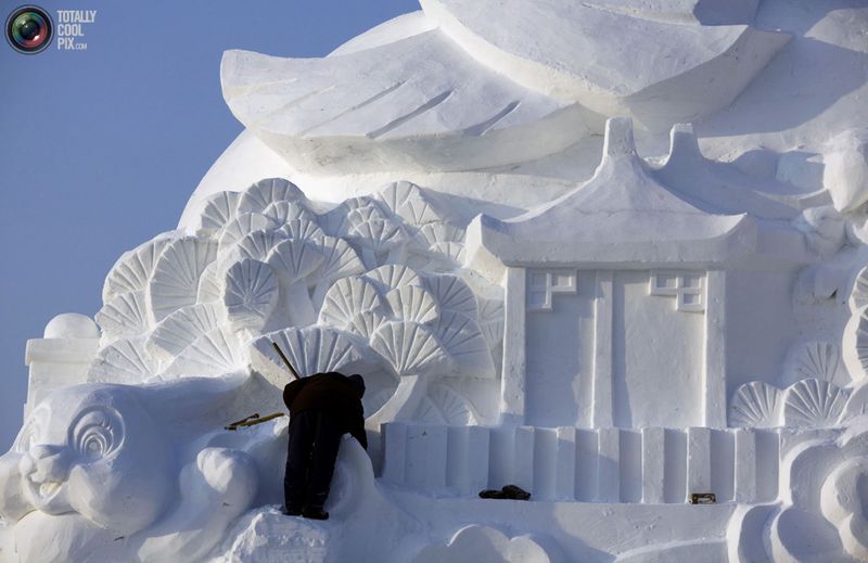 Рабочий заканчивает скульптуру из снега. (REUTERS/David Gray)