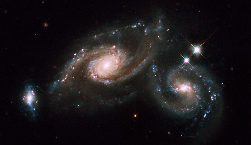 22. Триплет галактик Arp 274. В эту систему входят две спиральные галактики и одна неправильной формы. Объект находится в созвездии Девы.