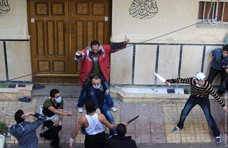 Мусульманин (в красном) и несколько христиан пытаются не дать проникнуть в мечеть атакующим христианам-коптам.