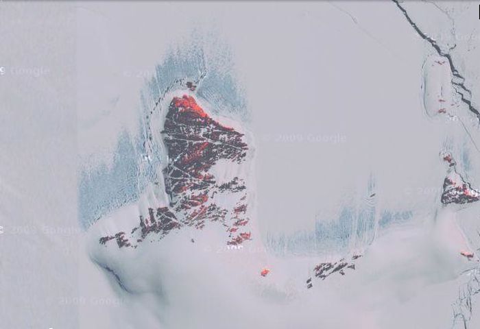 Полноэкранный режим Кровавый снег Это снимок Антарктики со спутника. Сквозь снег пробиваются красные горы. 