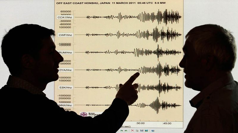 Сейсмологи на фоне диаграммы, демонстрирующую мощность 
землетрясения в Японии. Снимок сделан в офисе британской геологической 
службы в Эдинбурге. 11 марта в пятницу на Японию обрушилось крупнейшее 
землетрясение в истории страны. (David Moir/Reuters)