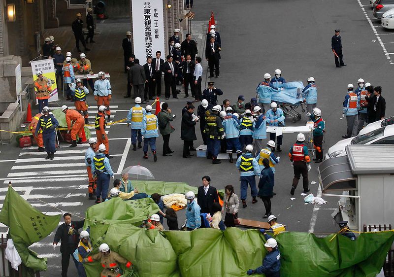 Спасатели спешат к зданию после сообщений о жертвах в финансовом 
районе Токио. После землетрясения было несколько ощутимых афтершоков и 
мощное цунами, обрушившееся на прибрежные города страны. (Kim 
Kyung-Hoon/Reuters)