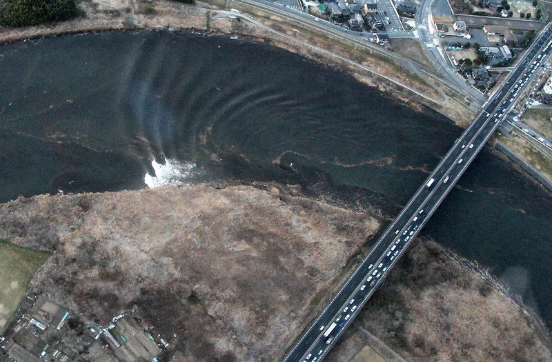 Вид с воздуха на движение цунами в реке Нака в Хитачинаке, 
префектура Ибараки. (AFP/Getty Images)