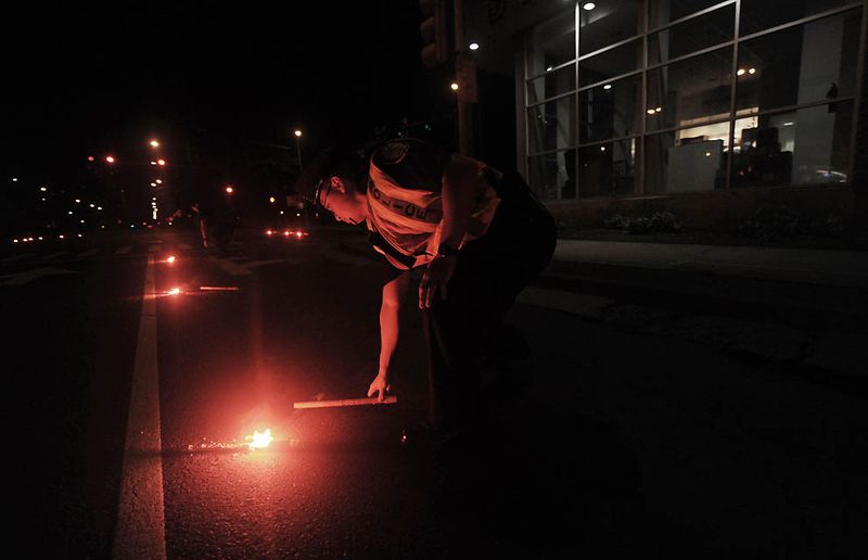Полицейские кладут на дорогу факелы в Гонолулу. После того, как 
землетрясение силой в 8,9 баллов обрушилось на побережье Японии, вызвав 
цунами, тысячи людей на Гавайях были эвакуированы из своих домов. (Lucy 
Pemoni/Getty Images)