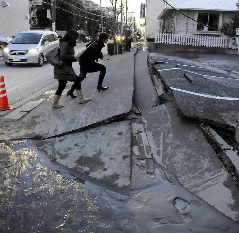 Прохожие на разрушенной дороге после землетрясения в Урауасу, префектура Чиба. (Toshifumi Kitamura/AFP/Getty Images)