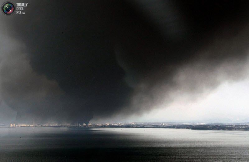 Густой черный дым над городом в префектуре Мияги, 12 марта 2011 
года.