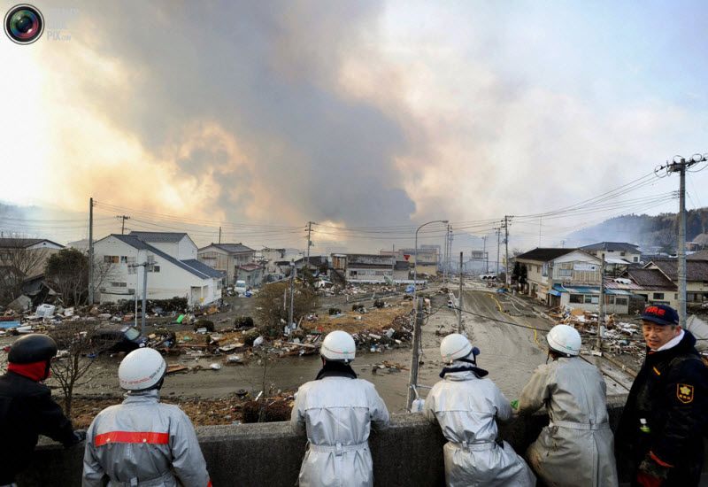 Пожарные смотрят на поднимающийся над городом дым, префектура 
Мияги, северо-восток Японии, 12 марта 2011 года.