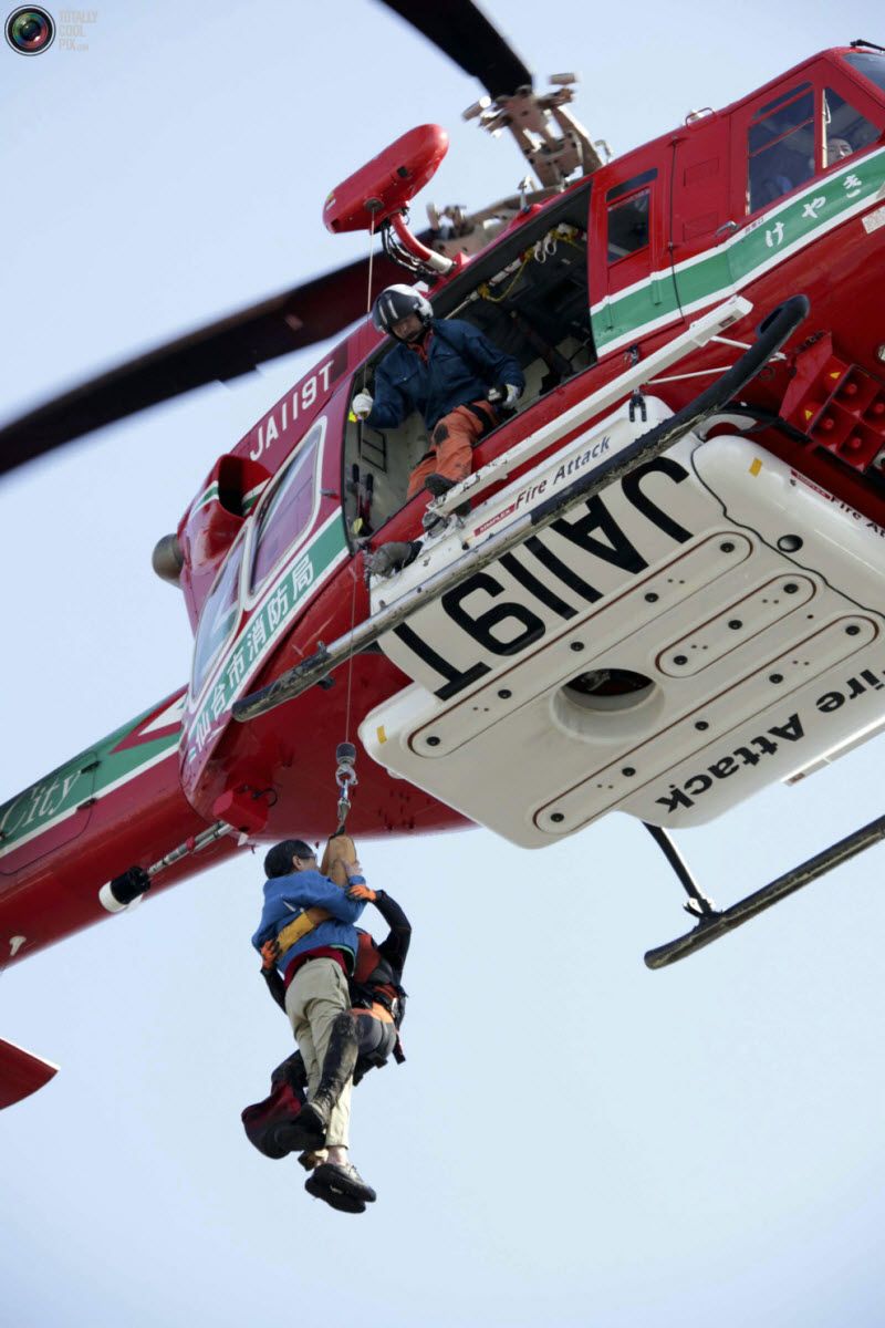 Женщину спасает вертолет в Сендай.