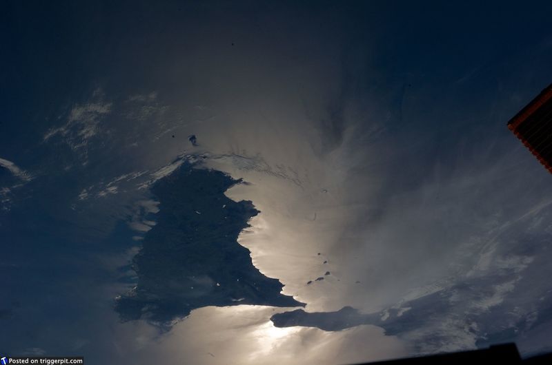 20. Сицилия, Италия<br>Сицилию прозвали родиной мафии благодаря фильмам «Крестный отец». Но на самом деле это красивый и волшебный остров, полный страстных людей, любящих музыку и еду, и кто-то из них смело живут в тени вулкана Этна. На этом снимке неясно, что отражается от Средиземного моря – солнечный или лунный свет. В любом случае, снимок удивительный. (NASA/ESA)