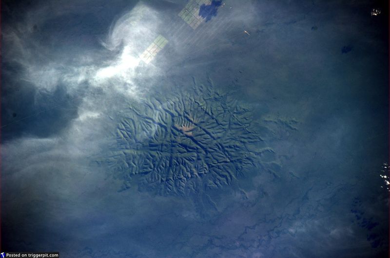 29. Национальный парк Чако, Парагвай<br>Чако – это равнина площадью примерно один миллион кв.км. Она захватывает части Боливии, Парагвая, Бразилии и Аргентины. Облака по краям превращают планету в низу в чешую огромной ящерицы. Может, где-то там затаилась Годзилла? (NASA/ESA)