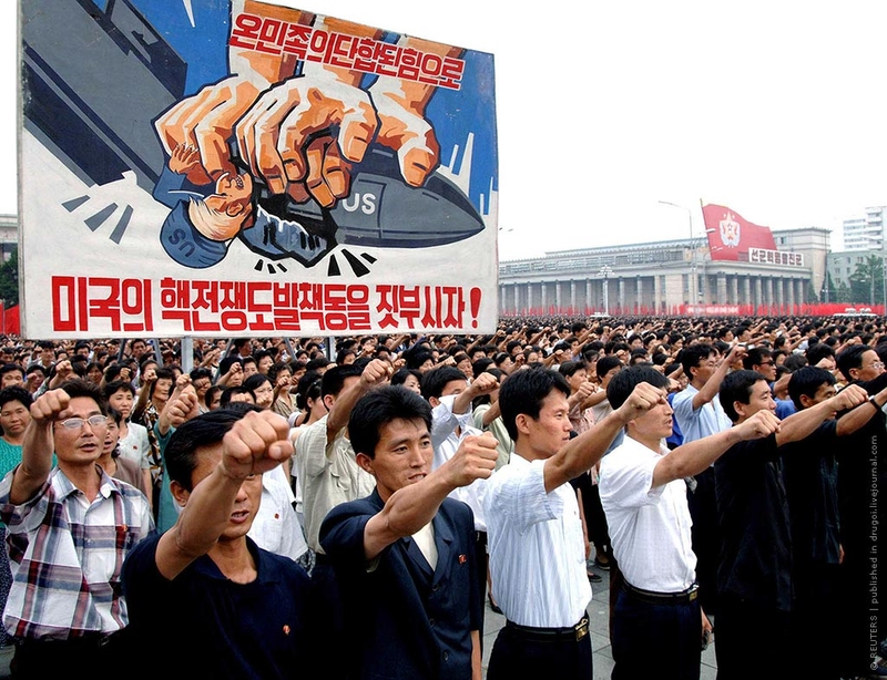 25.06.2009, КНДР | Жители Северной Кореи принимают участие в массовой демонстрации, устроенной на главной площади Пхеньяна в честь 59-й годовщины начала Корейской войны (1950-1953). На плакате написано примерно так: 
