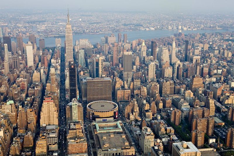 Коммерческие и жилые здания, в том числе Эмпайр Стейт Билдинг слева
 и Мэдисон-Сквер-Гарден в центре, в центральной части Манхэттена