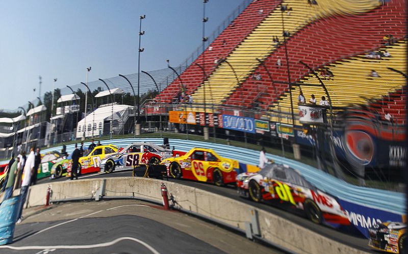 Отражение машин, готовых отправиться в квалификационный заезд гонки NASCAR, 7 августа, Нью-Йорк. (AP Photo/ Russ Hamilton Sr)