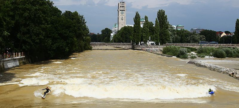 Серфер и каноист во время соревнований на реке Исар в Мюнхене 7 августа. Волны появляются на этой реке только тогда, когда она разливается. (Sandra Behne/Bongarts/Getty Images)