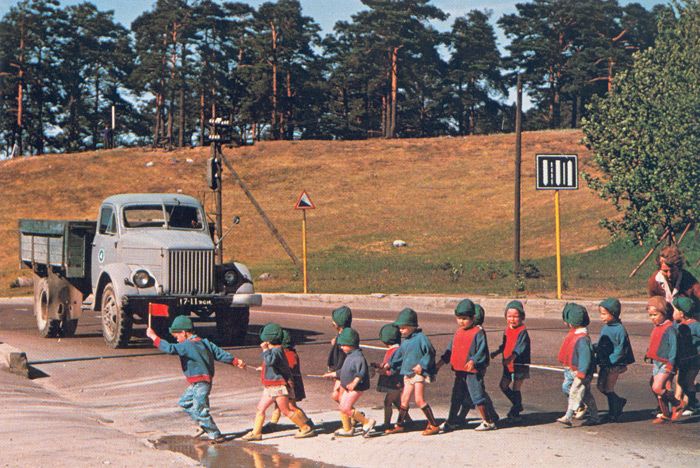 Маленький флажок в руке детсадовца останавливет движение на эстонской дороге.