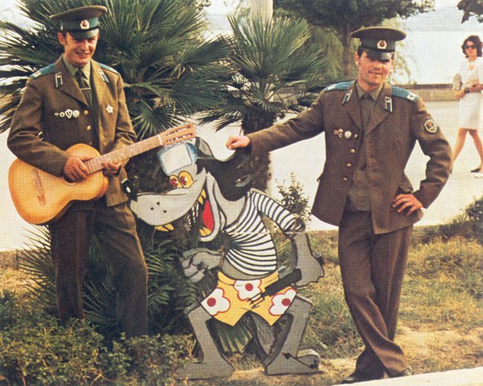 Солдаты в увольнении позируют для сувенирного фото с персонажем мультфильма.