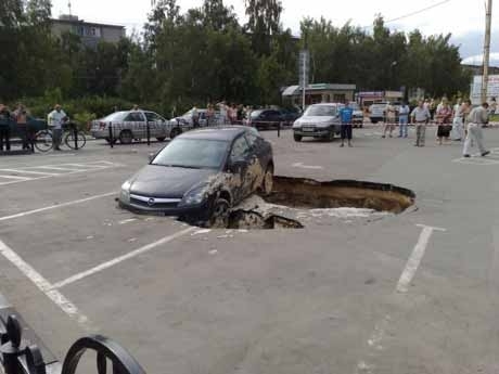 Opel провалился под землю в Дзержинске (9 фото)