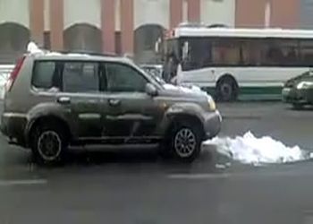 Девушка чистит снег с машины прямо на дороге