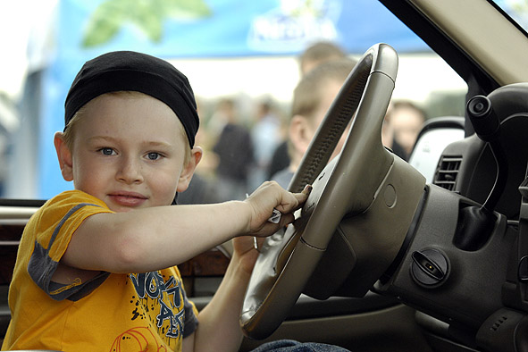 Машинами увлекаешься. Мальчик на автомобильной выставке. Мальчик не интересуется машинками.