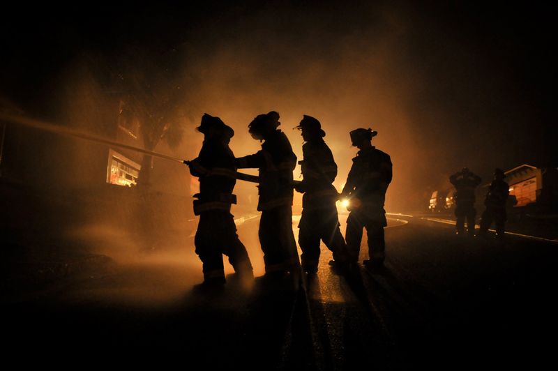 Отбрасывая силуэты на фоне фар своего автомобиля, пожарные пытаются потушить огонь, причиной которого стал взрыв газопровода недалеко от Сан-Франциско в сентябре 2010 года. Пожар уничтожил 37 домов и унес семь жизней. (Photo and caption by Josh Edelson)