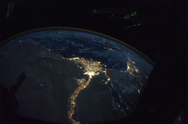 17. Ночной вид на реку Нил, тянущуюся змейкой через Египет к Средиземному морю, и Каир, расположенный в дельте реки. Какой контраст между темной безжизненной пустыней северной Африки и рекой Нил, на берегах которой кипит жизнь. Вдалеке на этом снимке, сделанном прекрасным осенним вечером, виднеется Средиземное море.
