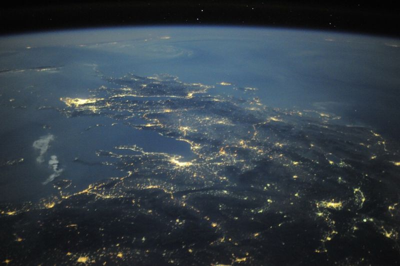 25. Греческие острова ясной ночью во время нашего полета над Европой. Афины ярко сияют вдоль Средиземного моря. Нереальное чувство возникает, когда видишь всю красоту древней земли из космоса.