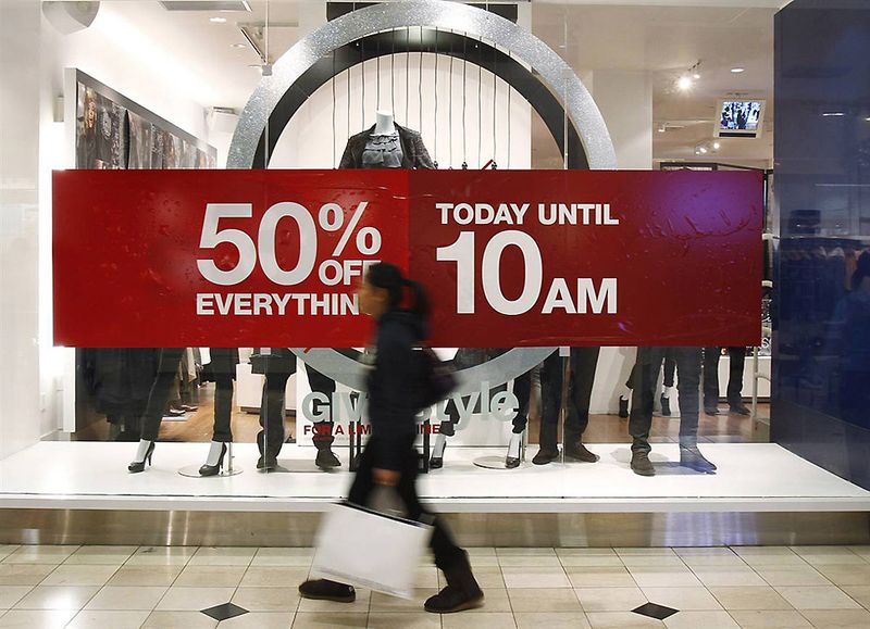 Женщина проходит мимо вывески с информацией о скидках на аллее магазинов Roosevelt Field Mall в Гарден Сити, Нью-Йорк. Надпись гласит: "50% скидки на все сегодня до 10 утра." (Shannon Stapleton / Reuters)