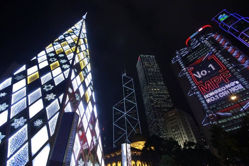 4. 29 ноября в Гонконге зажгли огни на 30-метровой пирамиде из кристаллических блоков на фоне небоскребов в финансовом районе. (Ym Yik / EPA)