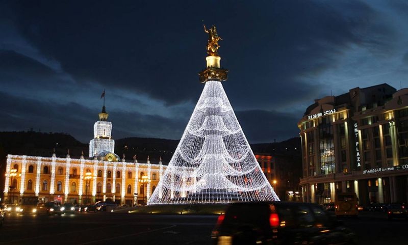 13. Иллюминация в виде новогодней ёлки украшает монумент Святого Георгия на площади Свободы в Тбилиси. (Shakh Aivazov / AP)