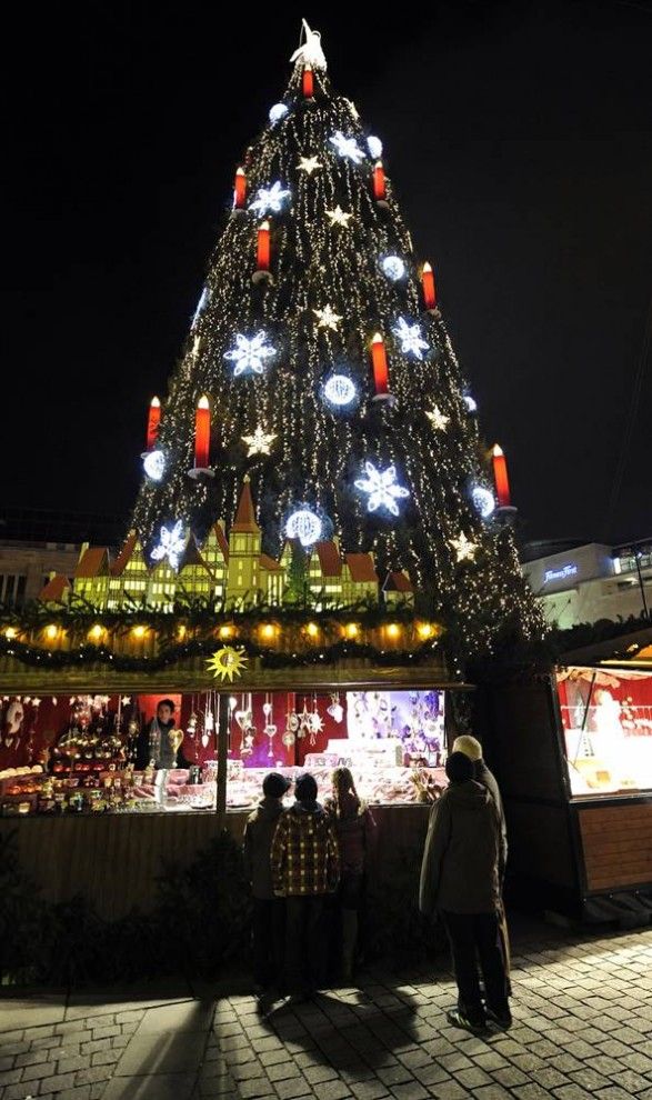 17. Люди стоят у прилавка одного из ларьков возле самой большой рождественской ёлки Германии в Дортмунде. 45-метровое дерево составлено из 1700 норвежских елей и украшено 48 тысячами лампочек. Традиционные рождественские ярмарки проводятся в Германии уже около 600 лет и открываются перед Рождеством почти во всех немецких городах. (Martin Meissner / AP)