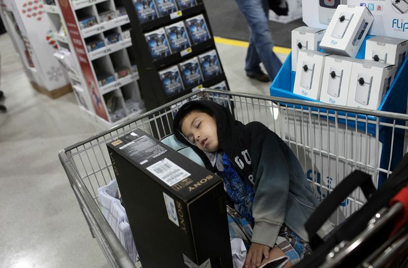 Шестилетний Джонатан Фернандес спит в тележке супермаркета «Best Buy» в Черную пятницу, после Дня Благодарения, 26 ноября в Неаполе, штат Флорида