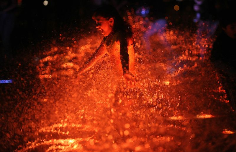 Девушка в воде, подсвечиваемой огнями, в Меделлине, Колумбия, 4 декабря. 