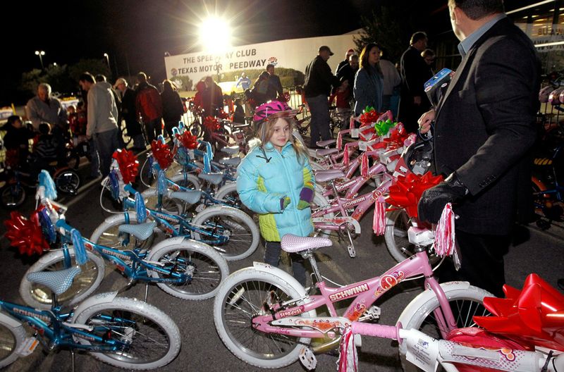 Семилетняя Джорни Скайерски выбирает новый велосипед и шлем во время церемонии зажжения елки на треке «Texas Motor Speedway» в Форт Ворте, штат Техас, 7 декабря. Организации «Childrens Charities», «Chalmer McWilliams» и «Texas Air Systems» предоставили новые велосипеды 100 детям. 