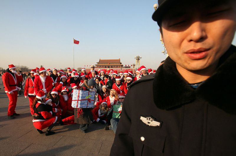 Китайская полиция разгоняет группу из 100 иностранцев, участвующих в мероприятии «СантаКон», на площади Тяньаньмэнь в Пекине 11 декабря. Подобные мероприятия проводятся по всему миру, но с площади Санта-Клаусов выгнали. 
