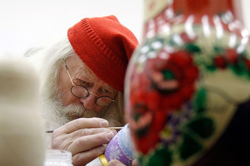 Мужчина в костюме Юлениссена – норвежского Санта-Клауса – раскрашивает матрешки в Москве 7 декабря.