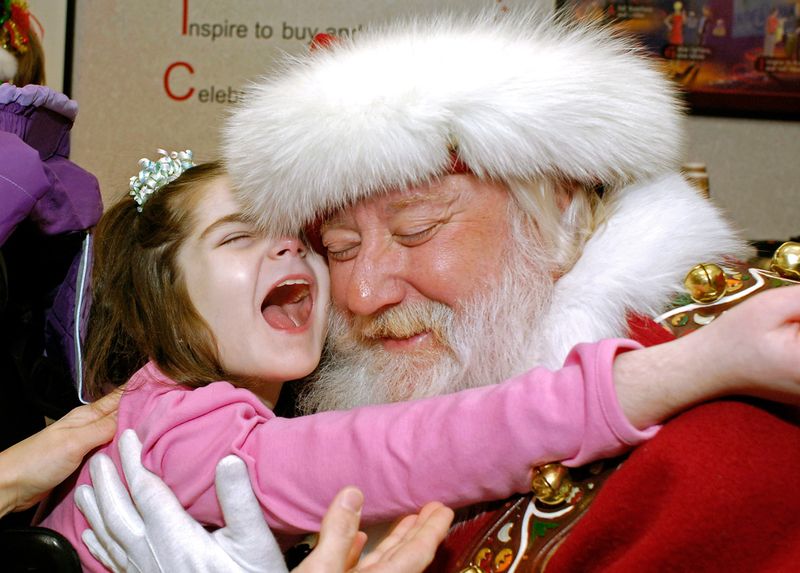 Восьмилетняя Эмма Мэар обнимает Санта-Клауса в универмаге «Macy's» в Чиктоваге, штат Нью-Йорк, 5 декабря. 
