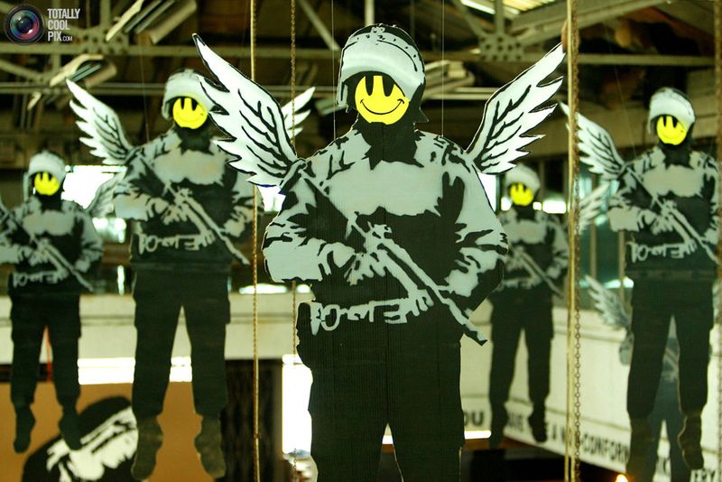 Картонные изображения полицейских с крыльями и смайликами вместо лиц на выставке «Turf War» в Лондоне 17 июля 2003 года. 