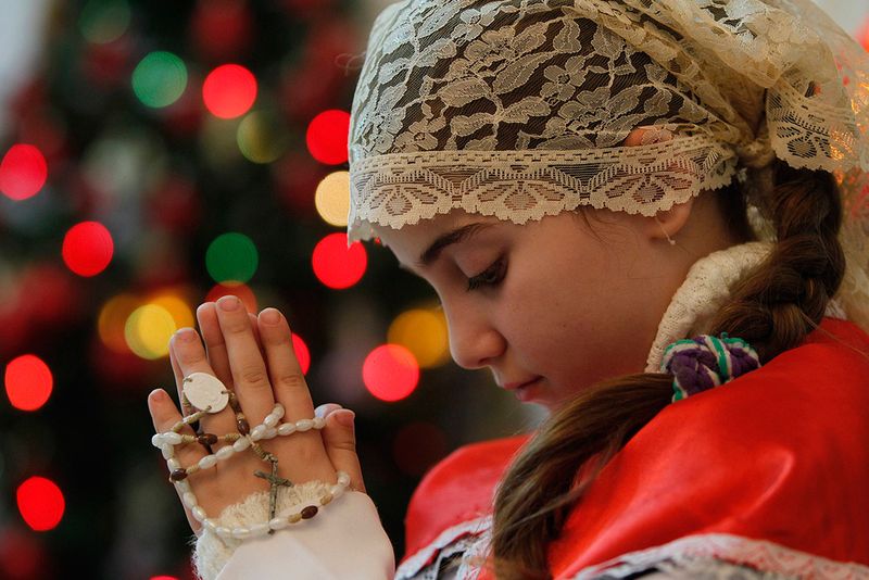 1. Иракская христианка на рождественской службе в католической церкви в Аммане, Иордания, 22 декабря. Тысячи иракских христиан бежали в соседнюю Иорданию после целой серии терактов в иракских церквях за последние несколько лет. (REUTERS/Ali Jarekji)