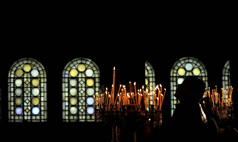 8. Мужчина молится во время рождественской службы в соборе Александра Невского с золотыми куполами в Софии 25 декабря. В Болгарии, в отличие от многих соседних православных стран рождество празднуется 25 декабря. (NIKOLAY DOYCHINOV/AFP/Getty Images)