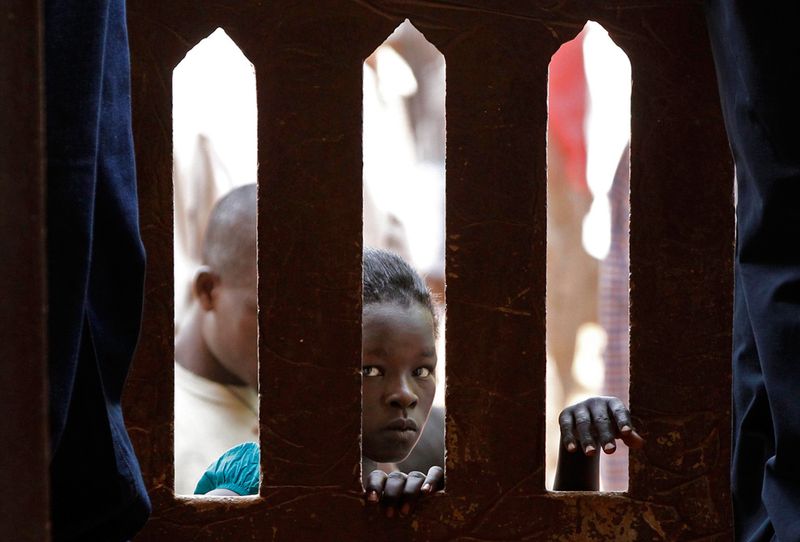 13. Суданская девочка заглядывает в собор святой Терезы, где проходит рождественская служба в Джубе. (REUTERS/Goran Tomasevic)