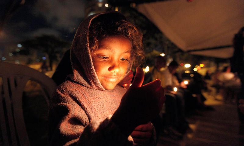 35. Бездомная девочка со свечой во время празднования рождества в парке Дом Педро в Сан-Паулу 24 декабря. Праздник был устроен благотворительной организацией «Альянса де Мизерикордиа». (REUTERS/Nacho Doce)